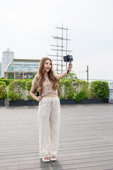 Fototapeta premium Asian beautiful woman backpacker taking a selfies outdoors in the city. 
