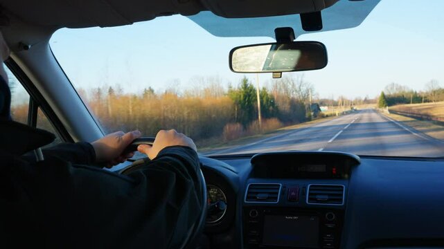 Rearview of emotional angry sad driver drinking and driving, depicting dangerous and illegal behavior swerving behind the wheel