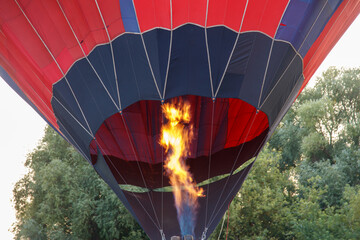 Obraz premium A hot air balloon with a red and orange striped body is floating in the sky