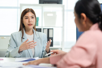 Obraz premium A professional woman engages in a discussion during a meeting, showcasing effective communication and collaboration in a modern office setting.