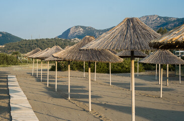 Wooden walkway to the beach with thatched umbrellas. concept - summer vacation at sea. lifestyle