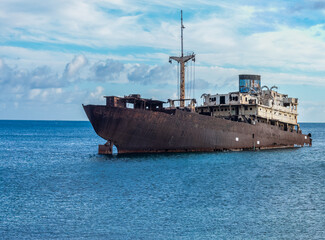 Rusted Shipwreck Resting in Tranquil Ocean Waters