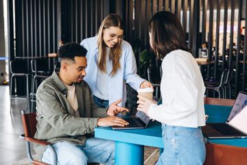 Obraz premium Diverse business team collaborating on laptop in modern office space