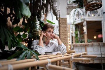 	
Woman natural surroundings and relaxed ambiance working or engaging in a digital task focused making it a perfect representation of work-life intently on her smartphone and a connection to nature