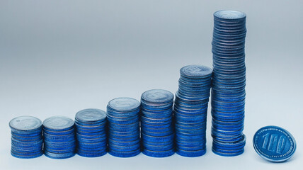 Innovative blend of blue coins arranged in bar chart formation, showcasing growth and financial progress. image conveys sense of prosperity and investment potential