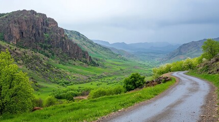Fototapeta premium Wet Road Winding Through Green Mountain Valley