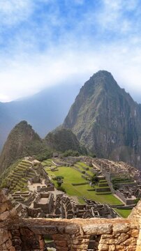 Machu Picchu through ancient stone walls - Vertical view