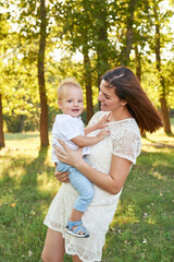 Autumn family walk in forest. Happy mother and baby boy. Family with little son in autumn park. Family and mother's day. Children Protection Day. Family picnic