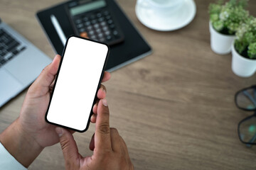 Top view Mockup image hand using a smartphone man Holding Cell Phone With Blank Screen