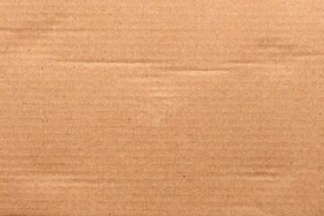 Brown corrugated cardboard with natural fibers and horizontal lines. Raw texture. Eco-friendly sustainable packaging. Abstract background. Rough surface of recycled material