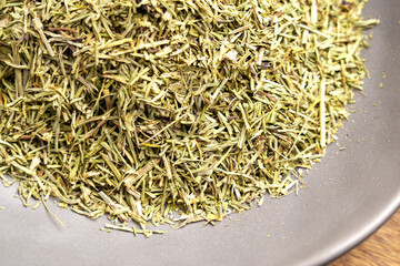 Medicinal healing horsetail tea leaves in ceramic bowl. Dried plant ingredient. Top view. Wellness concept