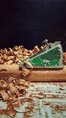 The photo captures a woodworking hobbyist using an old hand plane to shape a piece of mahogany. The...