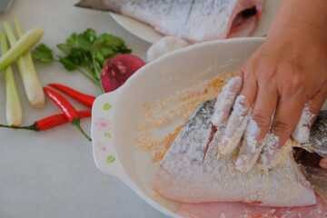 Hands of woman chef preparing fish food