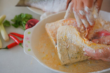 Hands of woman chef preparing fish food
