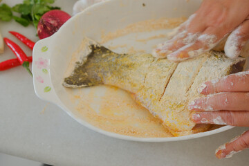 Hands of woman chef preparing fish food