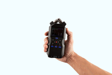 Male hand holding an audio recorder isolated on light cyan background