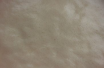 yeast dough with bubbles close-up top view as background