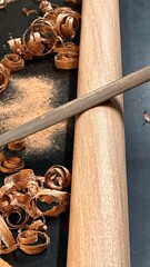 A woodworking hobbyist files a piece of mahogany, shaping the fine hardwood with precise, traditional craftsmanship.