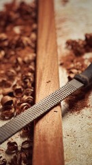 A woodworking hobbyist files a piece of mahogany, shaping the fine hardwood with precise, traditional craftsmanship.