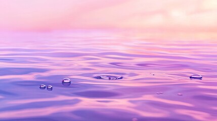 Water droplets ripple on calm pastel water surface