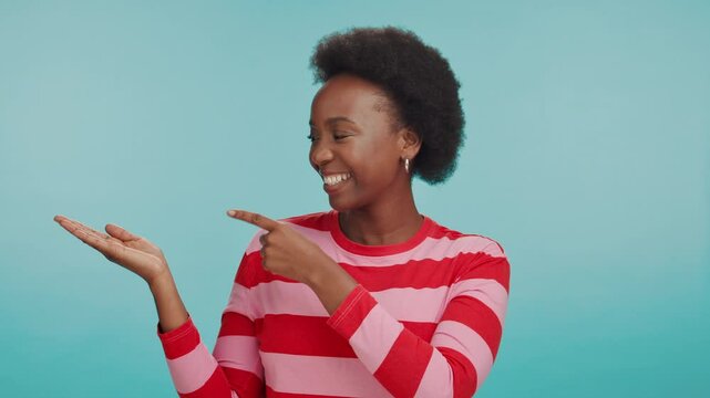 Show, pointing and face of black woman in studio for retail option, shopping budget plan and decision. Smile, mockup space and customer with person on blue background for discount code solution