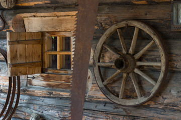 Obraz premium Wooden wheel and kerosene lamp on the walls of a log barn
