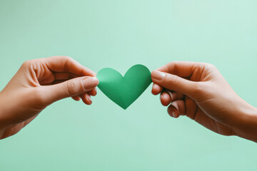 Fototapeta premium A female hand holding a green love heart. Love the environment concept. Eco conscious living