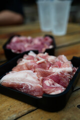 Raw pork marinated served on black tray for Thai style barbecue grill or Moo Krata