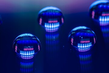 Blauleuchtende Wassertropfen auf reflektierenden Untergrund