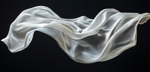 Fototapeta premium Soft, flowing white silk fabric gracefully suspended in the air, set against a Black background.