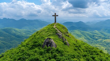 Black Cross on Lush Green Mountain Peak under Partly Cloudy Sky