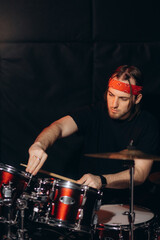 Drummer Adjusting Drum Kit in Music Studio for a Performance or Recording