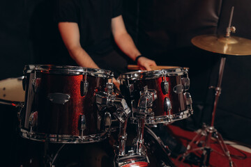 Drummer Performing With Red Drum Kit in a Studio Environment