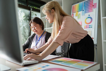 Creative graphic design team collaborating on digital projects in a bright office.