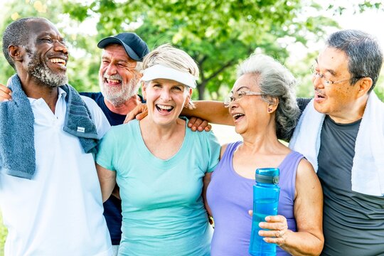 Group of healthy diverse seniors smiling outdoors, enjoying exercise in sunny day. Happy healthy senior friends, diverse ethnicity, enjoy in a park. Group of diverse healthy senior people in the park.