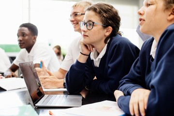 Diverse group of students in a classroom. Students including a girl, engaged in learning. Classroom...