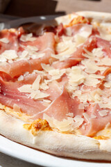 Closeup shot of a pizza with bacon and parmesan