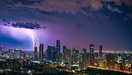 Obraz premium A breathtaking spectacle unfolds as a powerful lightning storm electrifies the night sky over a sprawling cityscape, casting an eerie yet mesmerizing purple glow.