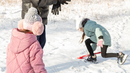 Little girls with her grandfather having fun on snowy winter day