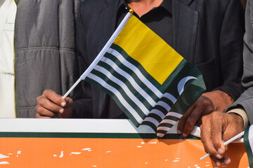 Kashmir national flag waving in male hand, Azad Kashmir flag isolated on white background. 