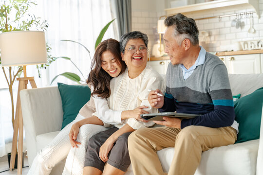 asian beautiful daughter and senior father and mother enjoying conversation and good time at home.happiness family and holiday at home,mother day concept.loving asian adult daughter sitting on couch