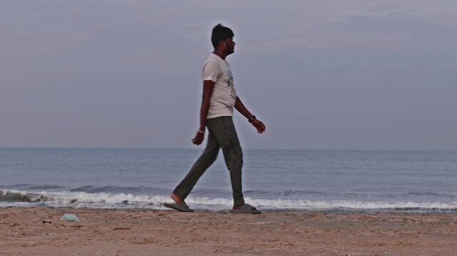 Indian person walking in marina beach or sand Beach at Triplicane, Chennai, Tamil Nadu, india. sun set time, pan shot, 4k.