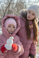 Two little girls playing on the playground on a winter day