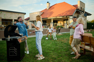 Happy family enjoying barbecue party in backyard