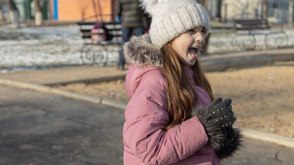 little girl playing on the playground on a winter day