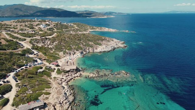 Scenic coastline drone shot of Tigania Beach in Sithonia Greece. Turquoise waters of Greek peninsula with tourists on vacation.