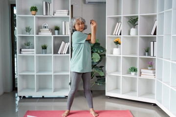 Senior woman performing stretching exercises at home, focusing on wellness and mobility.