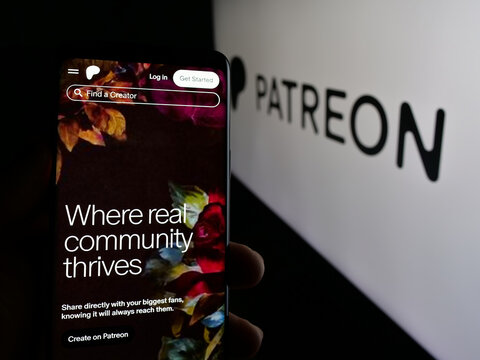Stuttgart, Germany - 01-28-2025: Person holding cellphone with webpage of US monetization platform company Patreon Inc. on screen in front of logo. Focus on center of phone display.