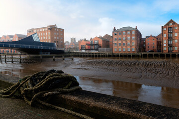 Low tide along the River Hull with bridge, flats, and church on the horizon.
