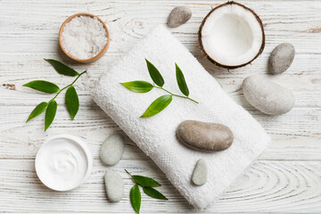 Coconut with jars of coconut oil and cosmetic cream on colored background. Top view. Free space for your text. Natural spa coconut cosmetics and organic treatment concept Coconut Spa composition